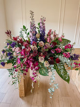 Load image into Gallery viewer, A colorful floral arrangement of fresh flowers with a variety of petals and green foliage, presented in a rectangular wooden casket.