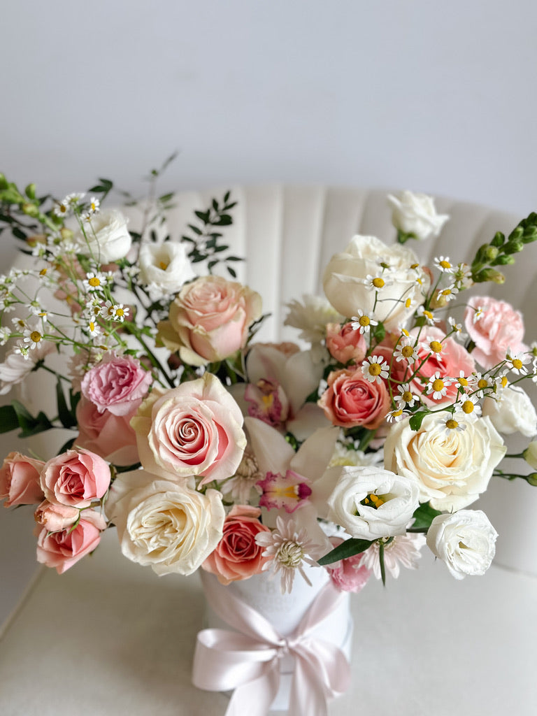 Bouquet of pink and white flowers with a white ribbon on a light background