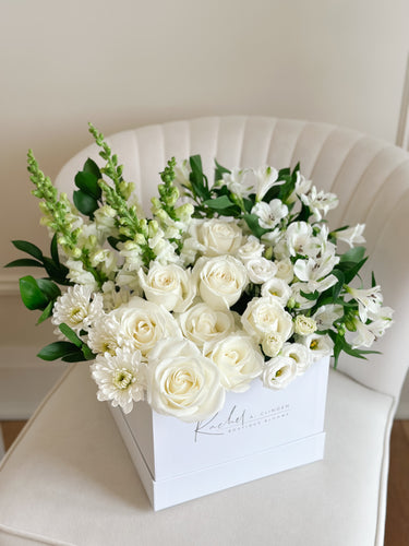 A contemporary arrangement of premium white flowers including roses and alstroemeria, displayed in an extra large box.