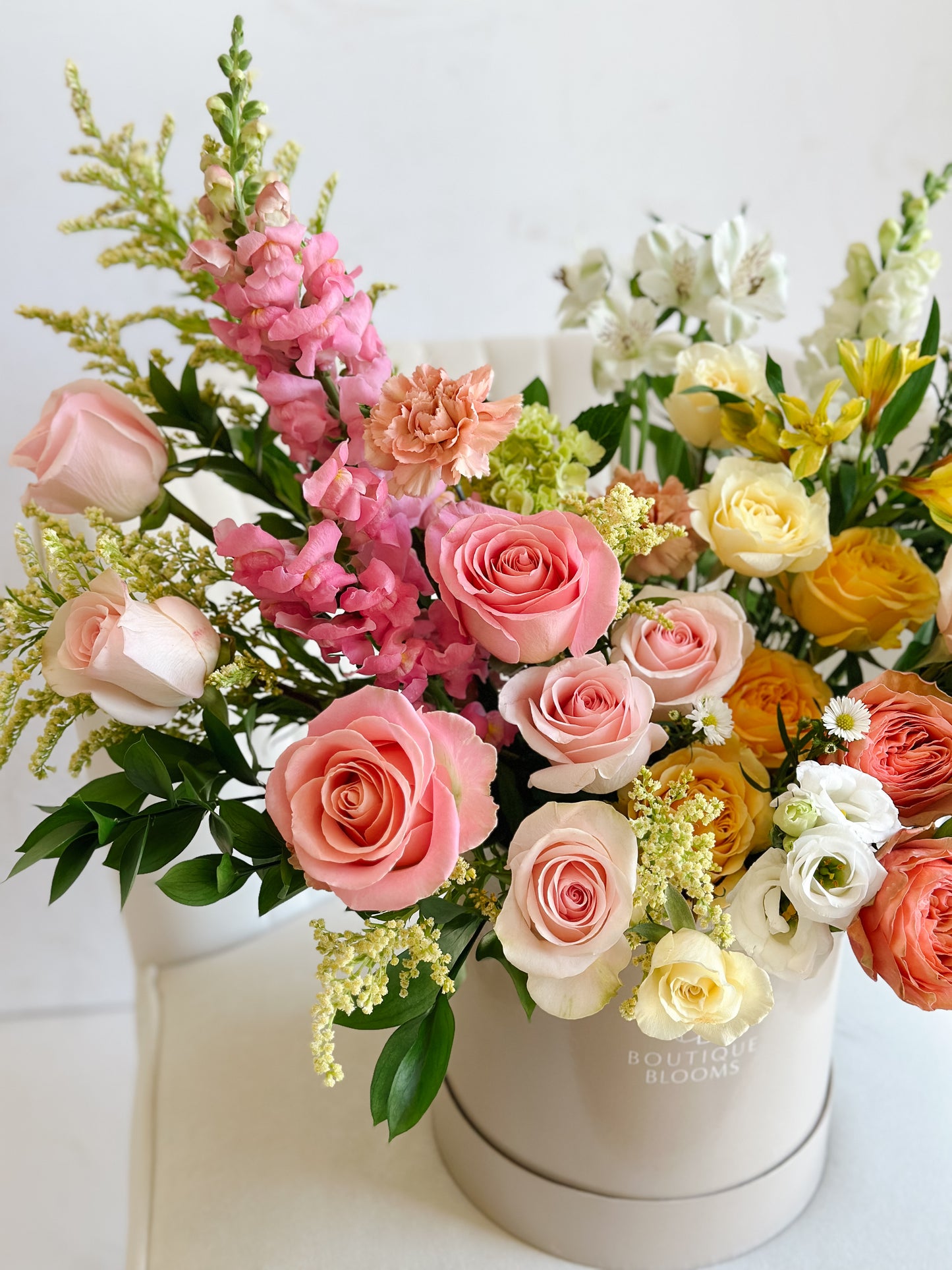 Elegant summer roses and seasonal florals styled in a modern Boutique Blooms hat box for Toronto delivery.