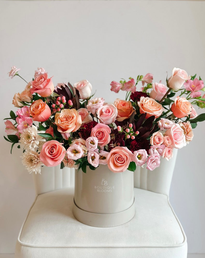 Bouquet of pink and purple flowers in a white box on a white background