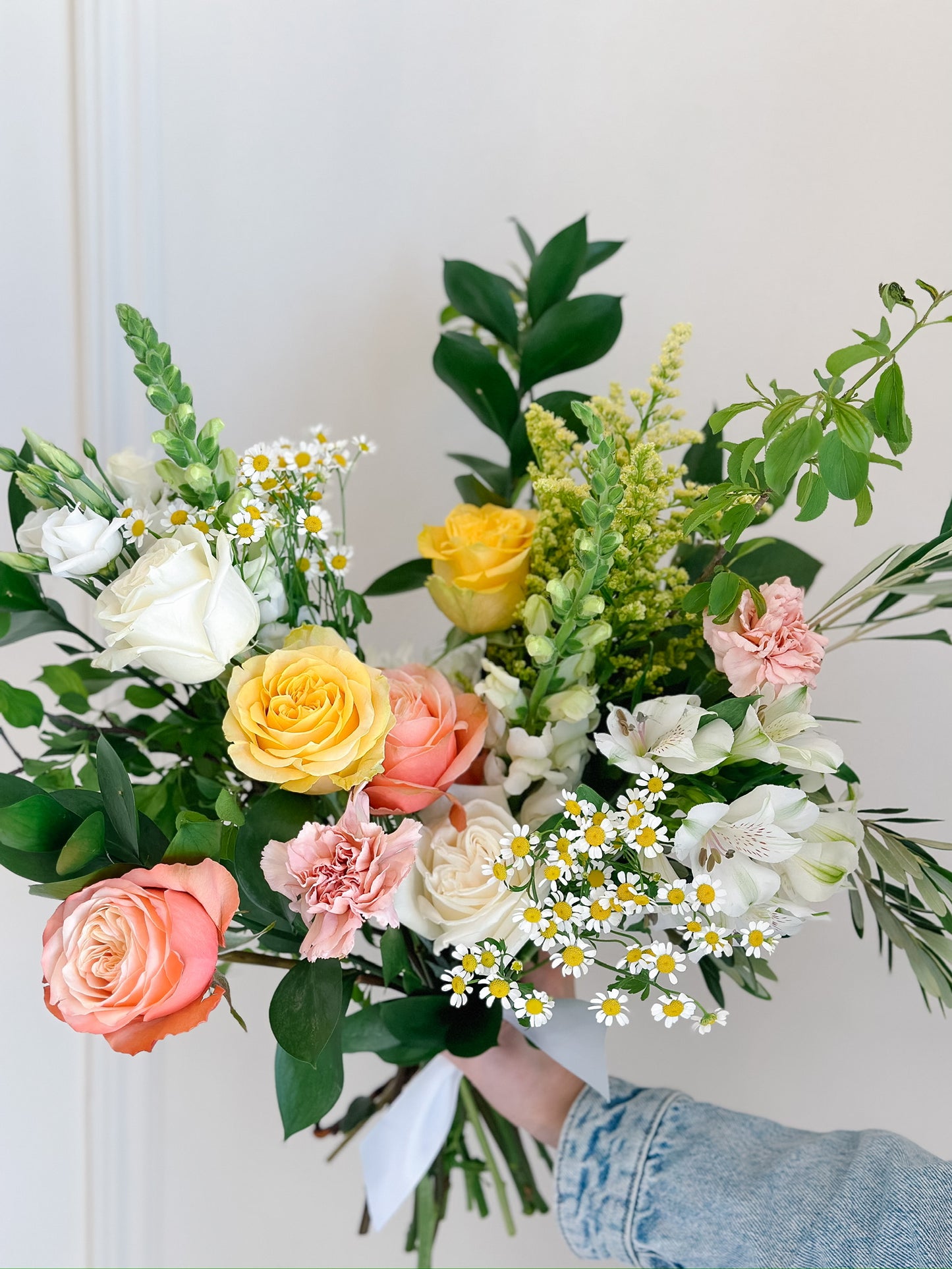 Bouquet of flowers held by a person against a white background