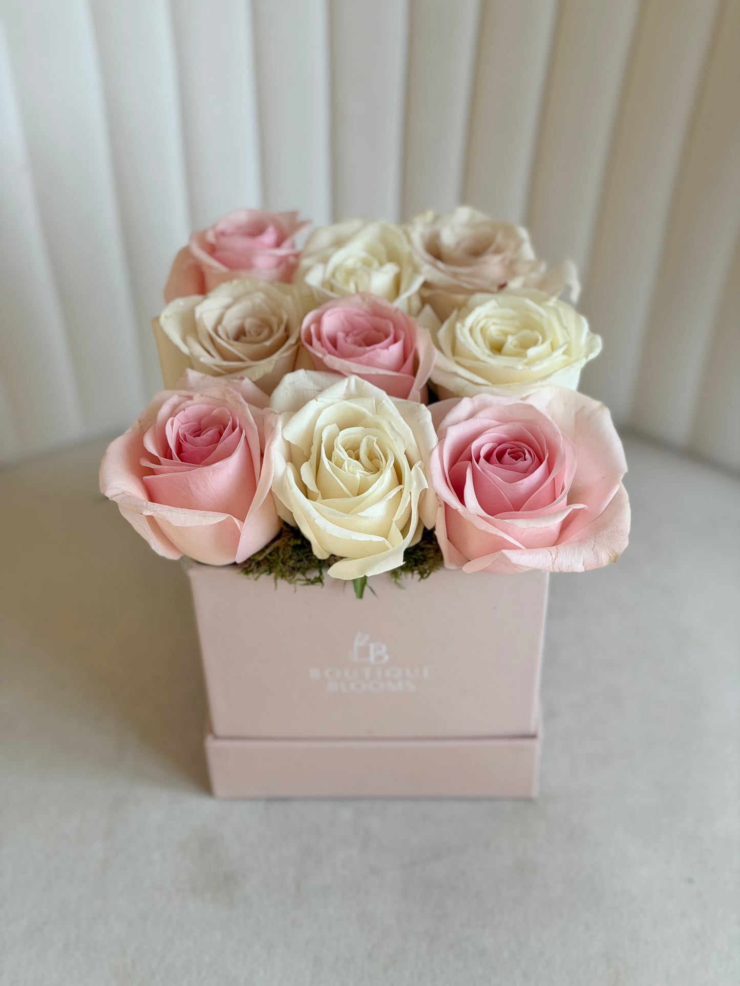 Pink and white roses in a box on a light background