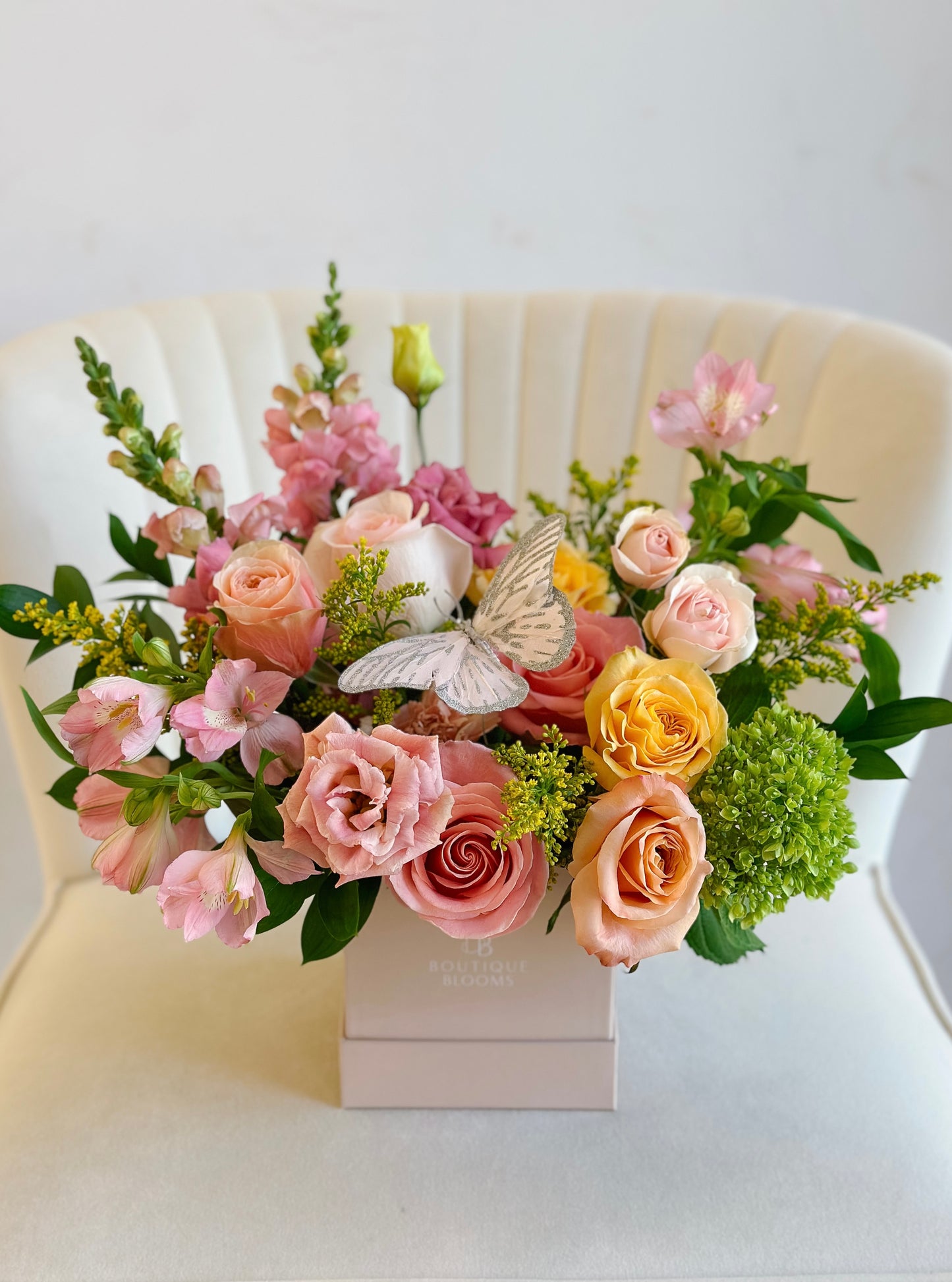 Bouquet of flowers with a butterfly on a white chair