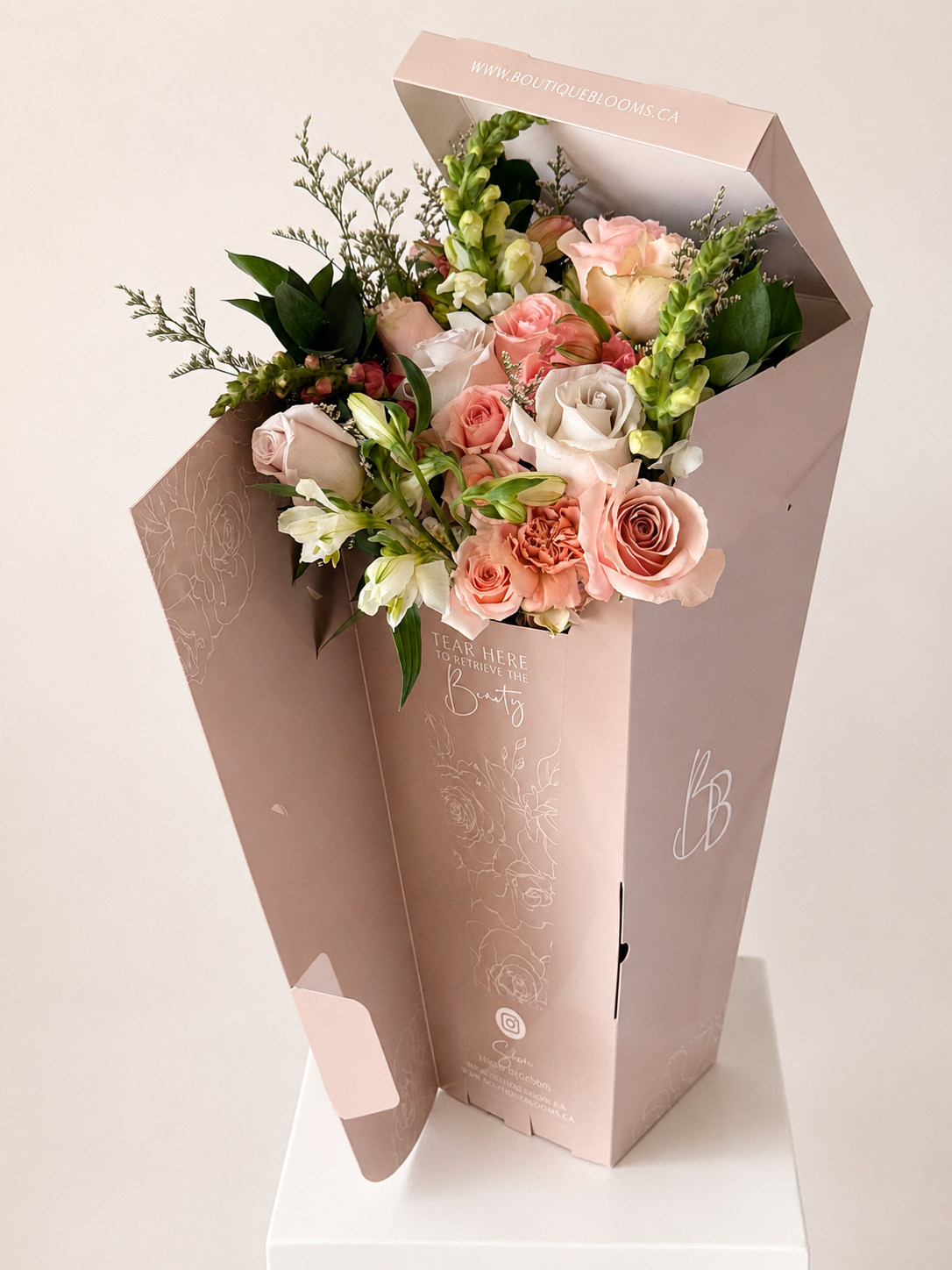 Bouquet of flowers in a decorative box on a light background