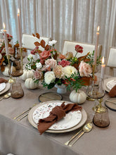 Load image into Gallery viewer, A thanksgiving table setting featuring an autumn centrepiece with floral in a vase, surrounded by white pumpkins, with plates, cutlery, and candles on a tablecloth.
