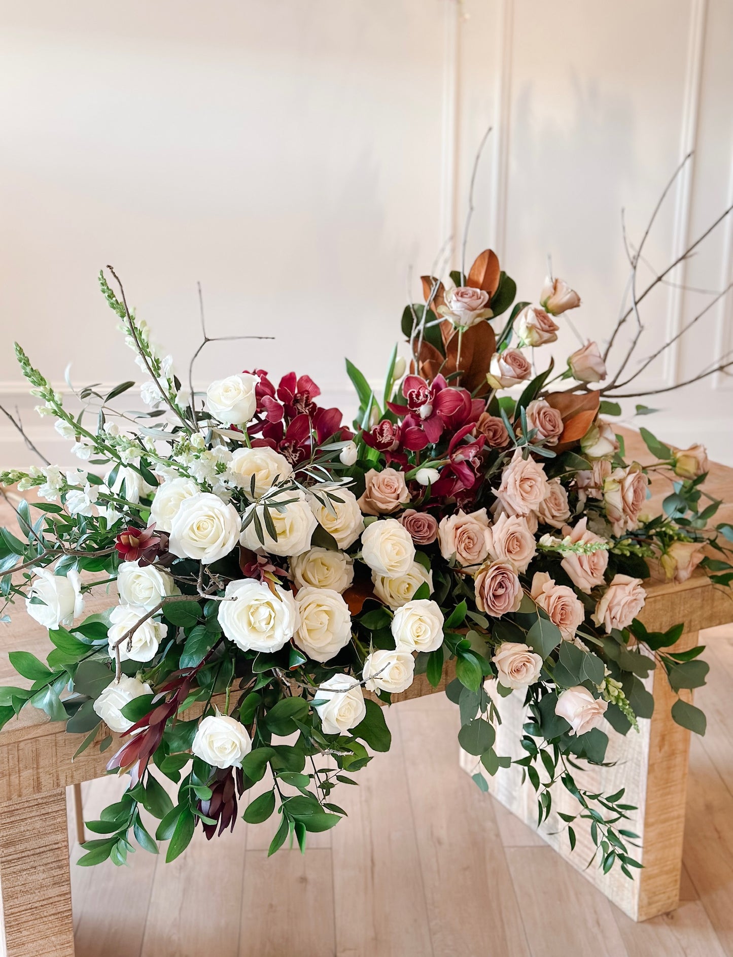 A floral arrangement with a variety of flowers including roses and other foliage, designed in shades of white, pink, and red, intended for use as funeral flowers.